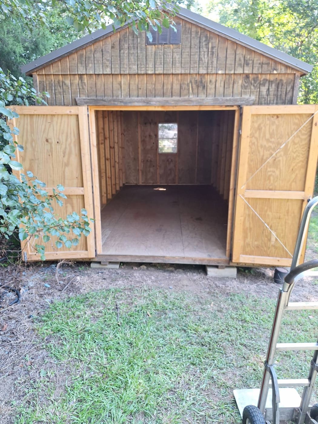 Shed with doors open showing a completely empty, clean interior