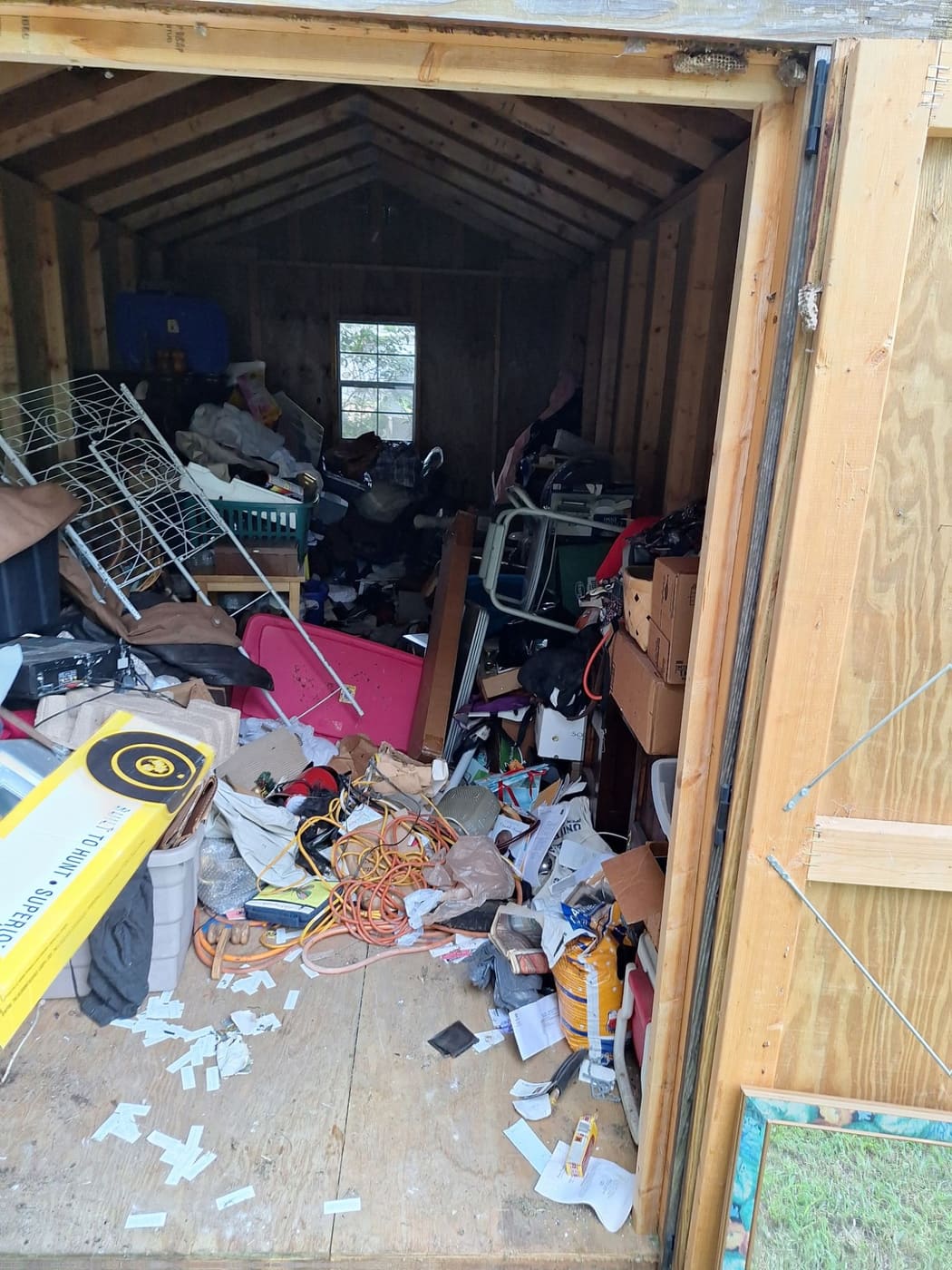 Shed doorway blocked by clutter, boxes and extension cords